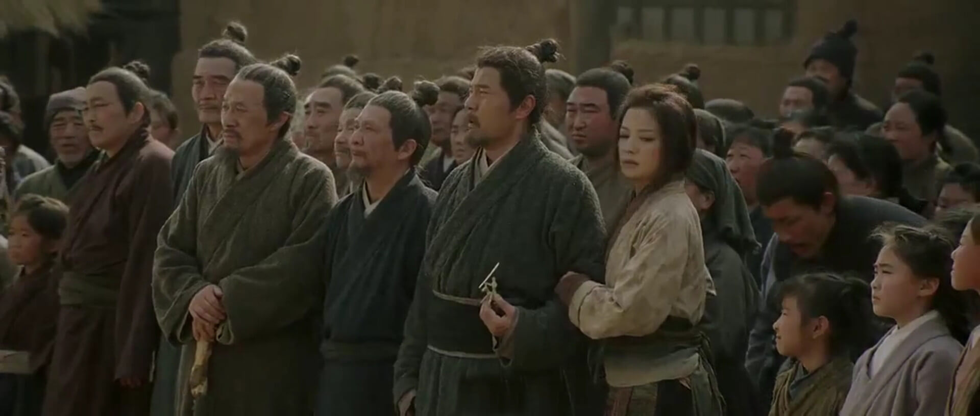 Mulan stands next to her father, Hua Hu, as he receives his conscription orders.